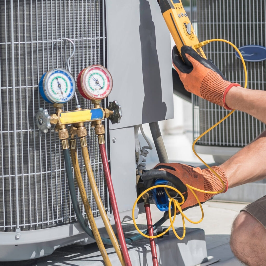 HVAC technician performing emergency diagnostic tests on an AC unit using professional gauges and tools