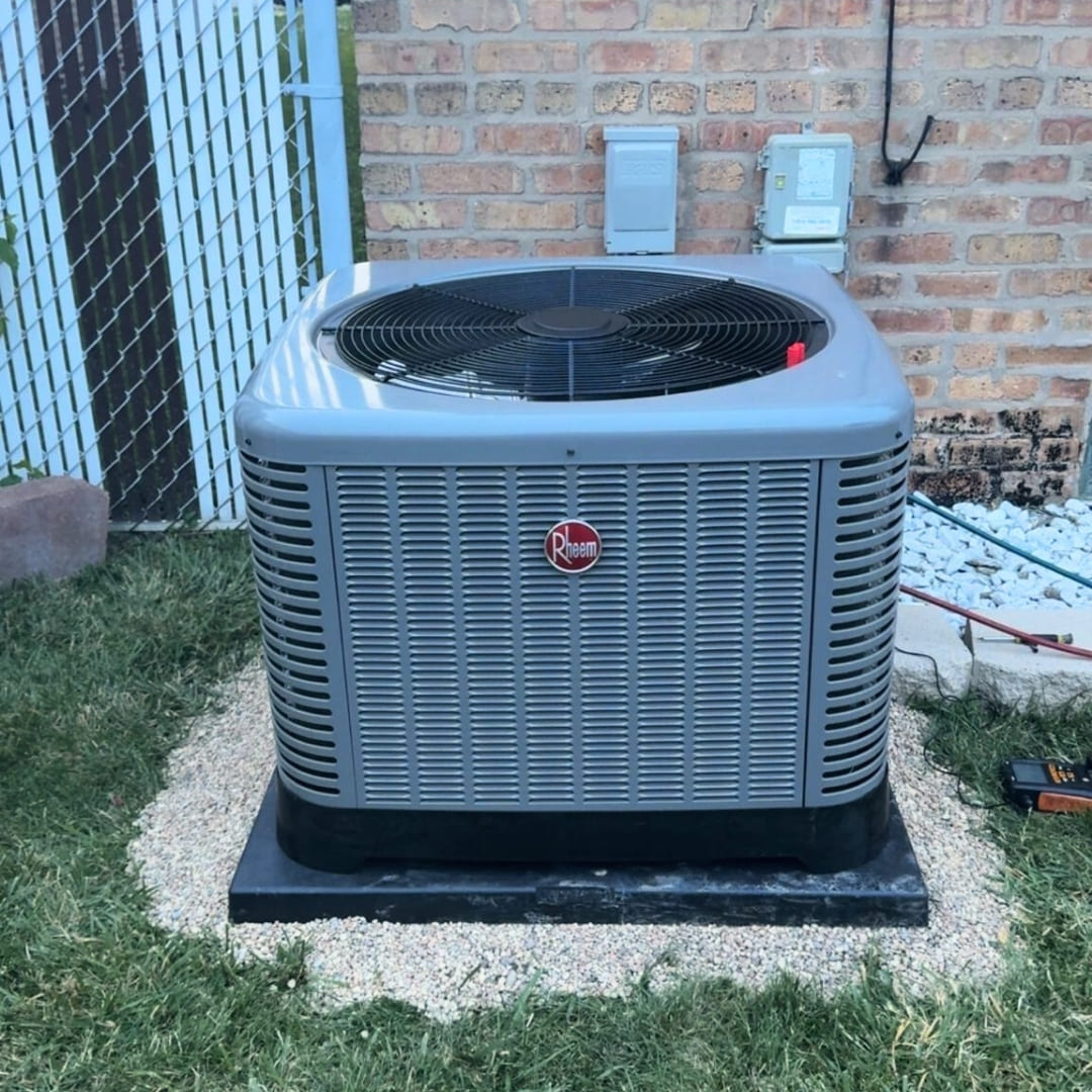 Professional central air conditioning unit installation on a reinforced base by SD Tech in a Chicago residential area